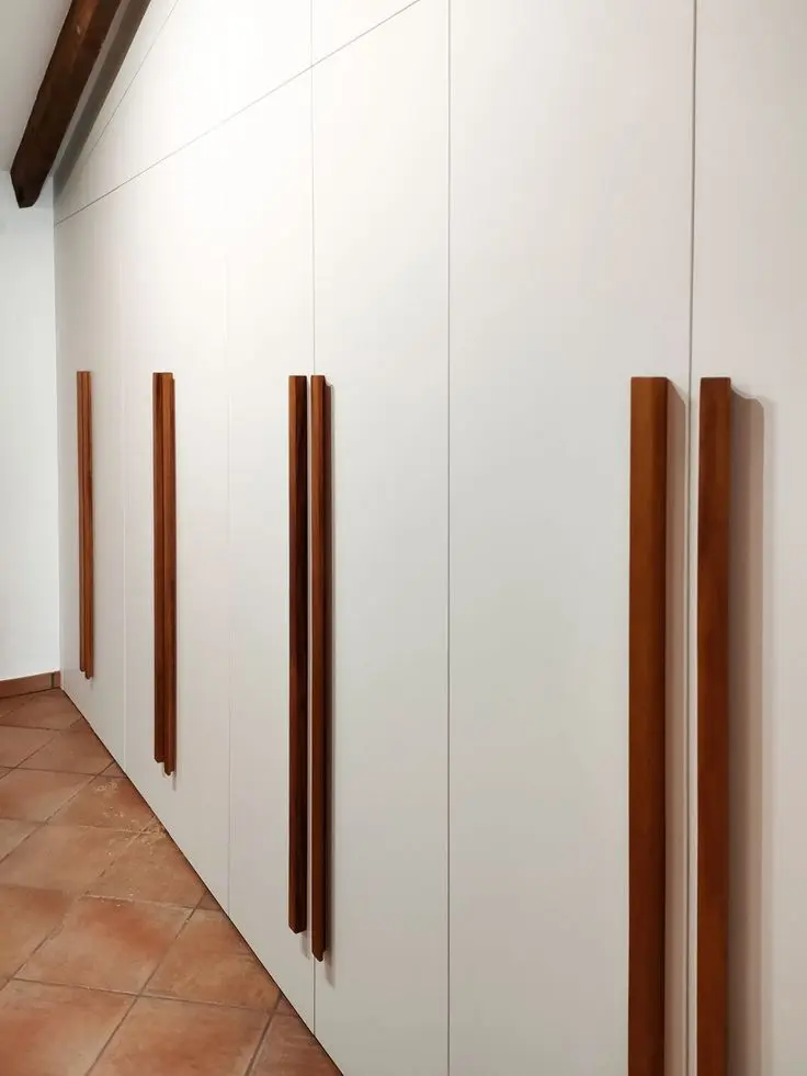Armario blanco con puertas abatibles y tiradores de madera Armario blanco con puertas abatibles y tiradores de madera de BNZ Mueble